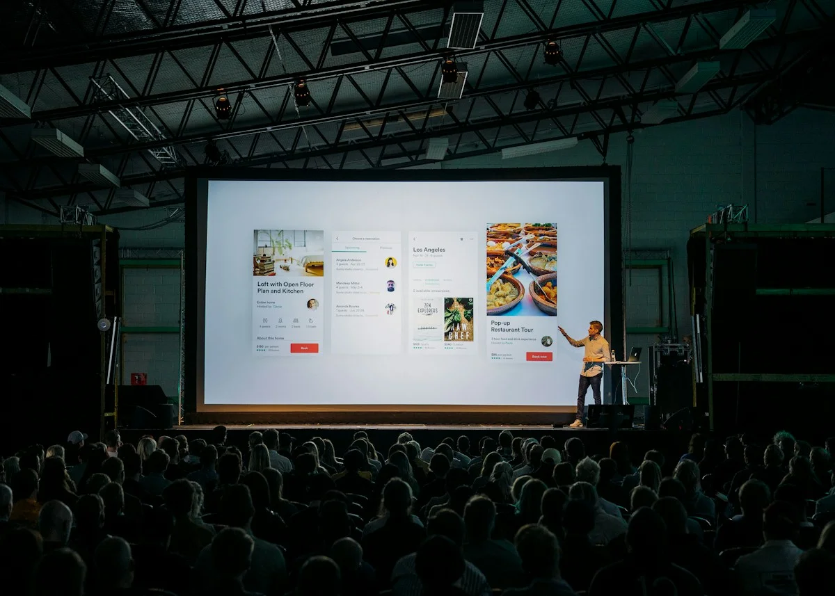 Illustrative business conference with a presenter and a large presentation screen
